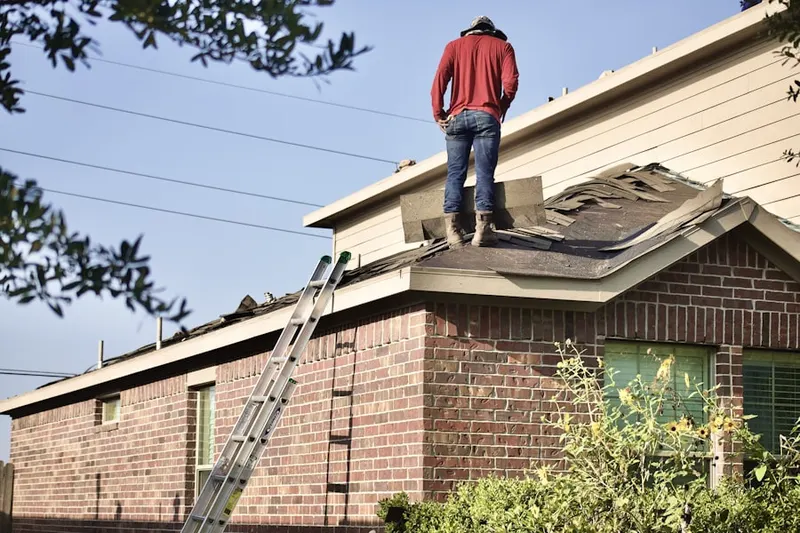 Professional roofer working on a residential roof in Marquard Manor